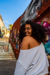 Traveler exploring a colorful graffiti-lined street in Brazil