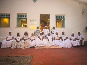 Black Brazilian community members wearing traditional white clothing outside a cultural center